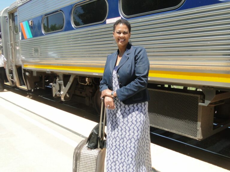 Tina Hayes, founder of the School of Etiquette and Decorum in front of train