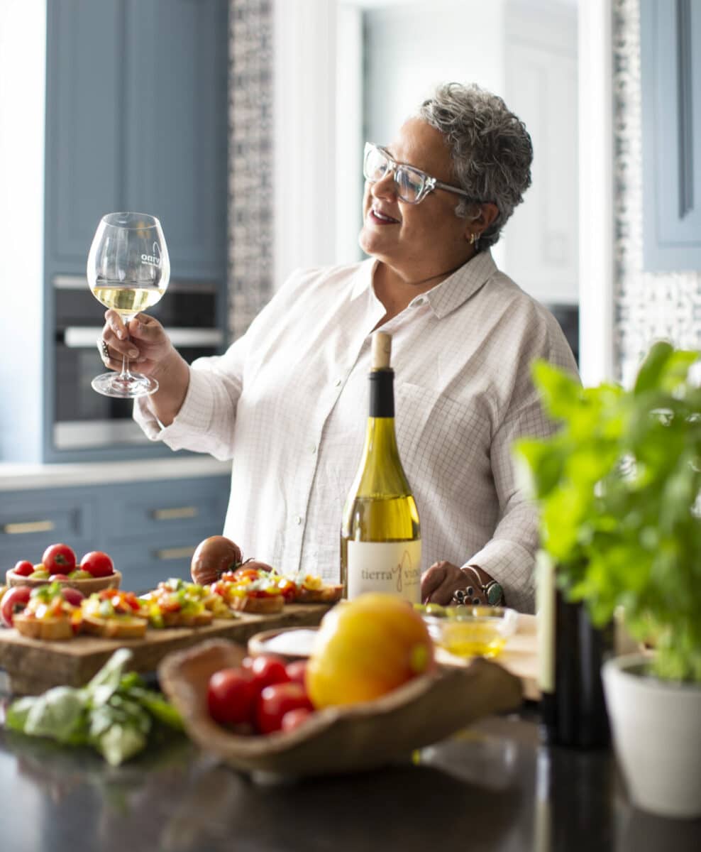 Kitchen designer Caren Rideau holding a glass of white from her label Tierra y Vino 