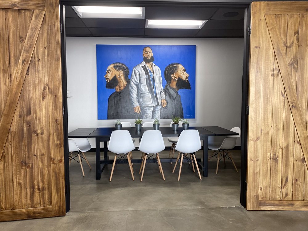 Community room inside of South LA Cafe with mural of the late rapper Nipsey Hussle
