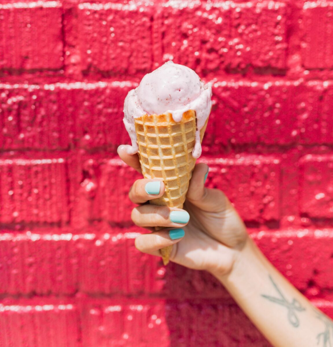 Strawberry ice cream on a waffle cone by Ruby Scoops