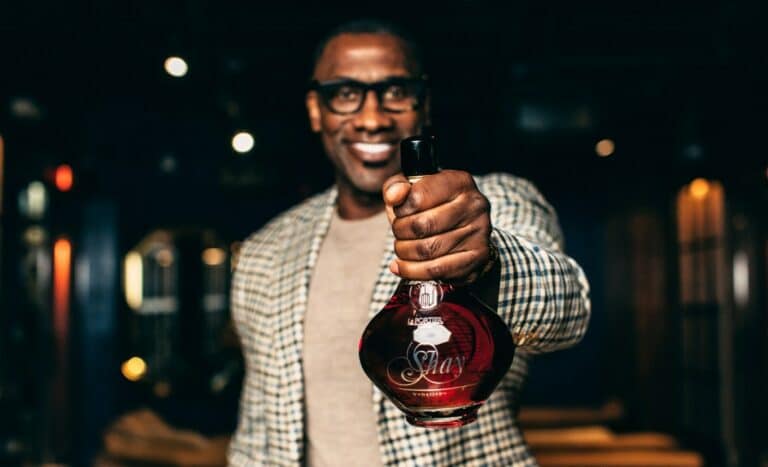 Shannon Sharpe holding Shay by Le Portier