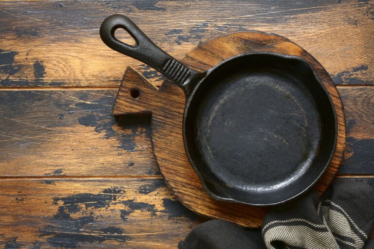 Empty cast iron pan on dark old wooden rustic table